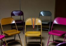 LGBTQ+ Support Groups: How They Help and Where to Find Them Empty chair circle with rainbow lanyard and scattered donuts in basement.